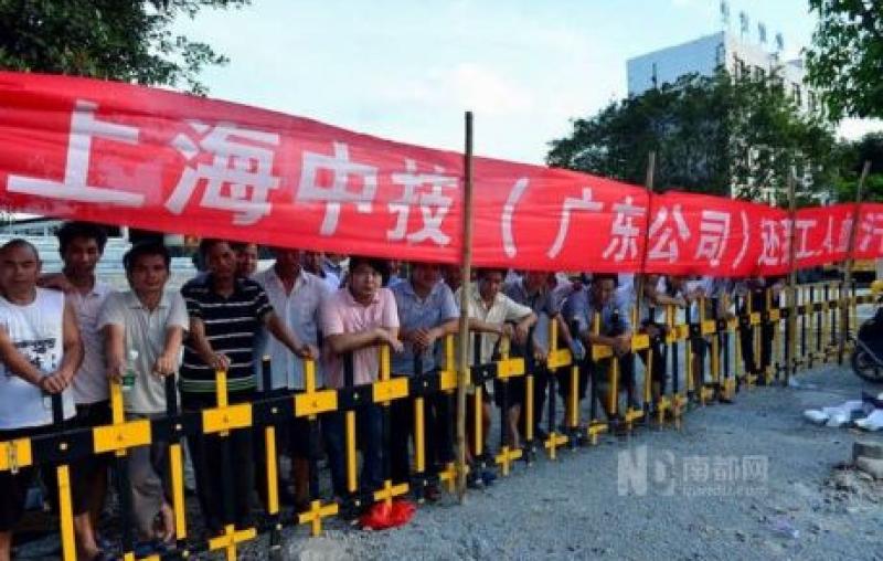 Workers guarding the entrance to stop management people from leaving